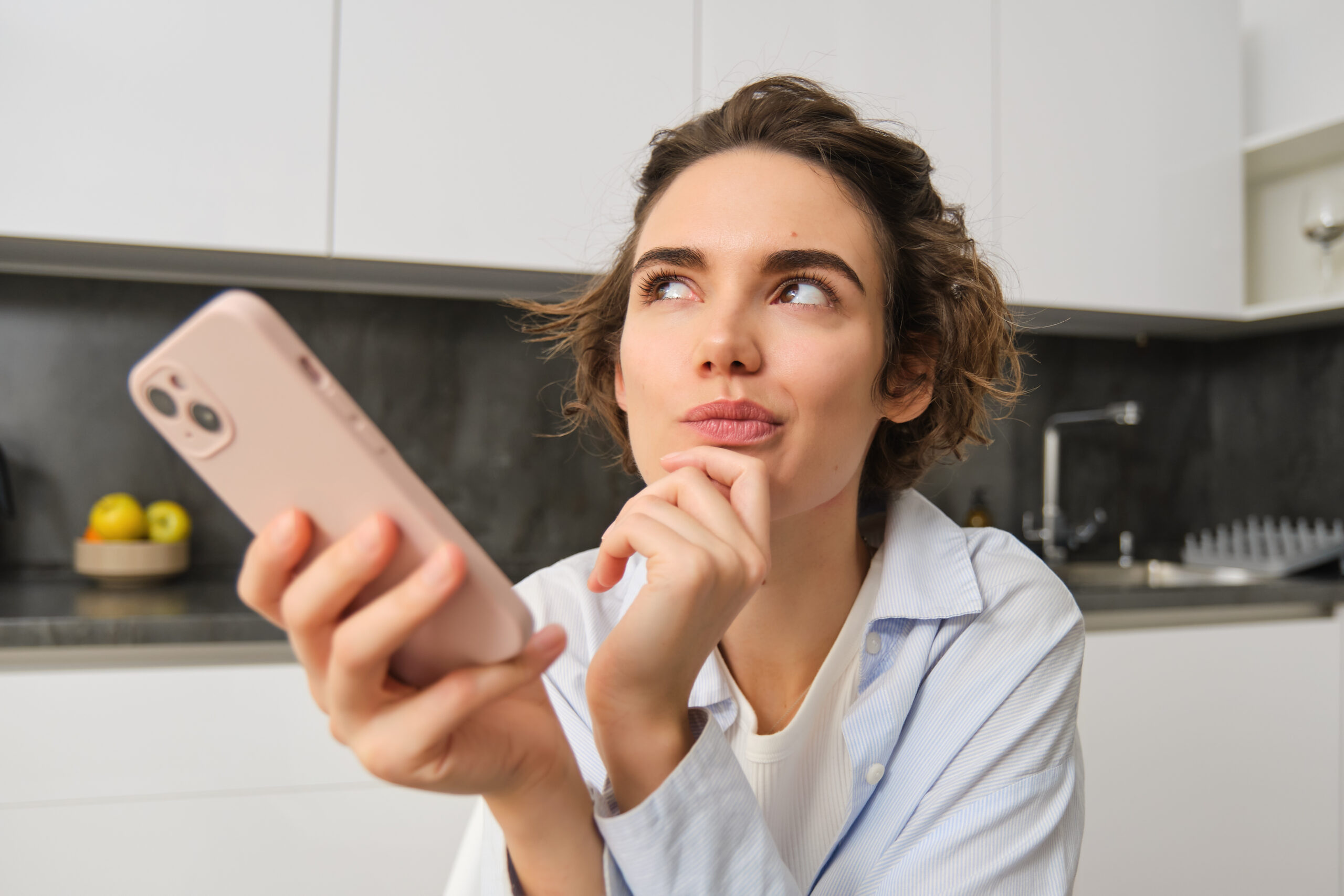 Portrait of woman at home, holding smartphone, digital planning strategy social media